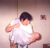 Babies often fall asleep in the comfort of the Heart-to-Heart baby sling. You can continue to carry your baby comfortably, while sleeping. But if you need to but the baby down, here's how... Loosen the sling by lifting the bottom ring. Supporting baby with your arm, lean over the bed, and lay your baby down. Slip the sling over your head, or undo the rings. Makes a handy blanket